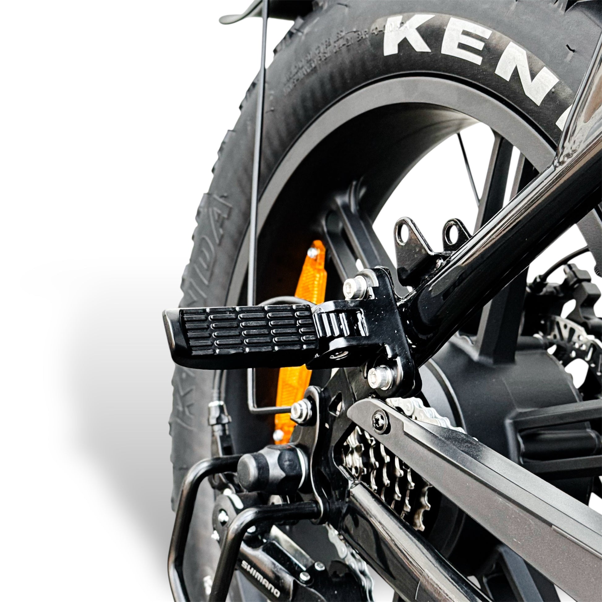 Close-up of a motorcycle's rear wheel and passenger's foot peg on Dalat V1 Electric Bike