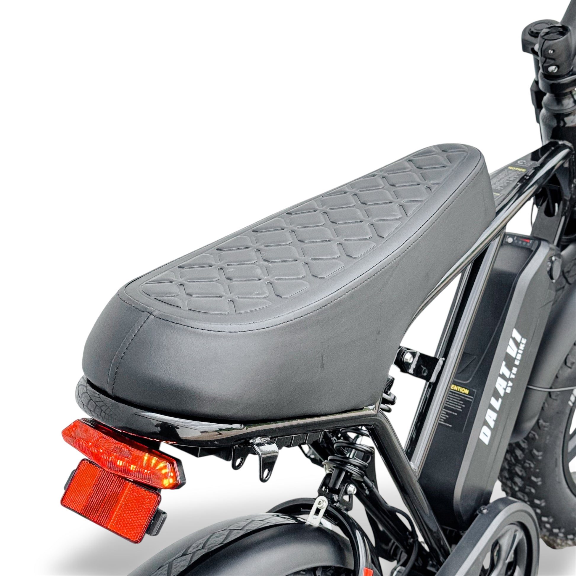 Close-up of a black motorcycle style ebike seat with a red reflector on a white background