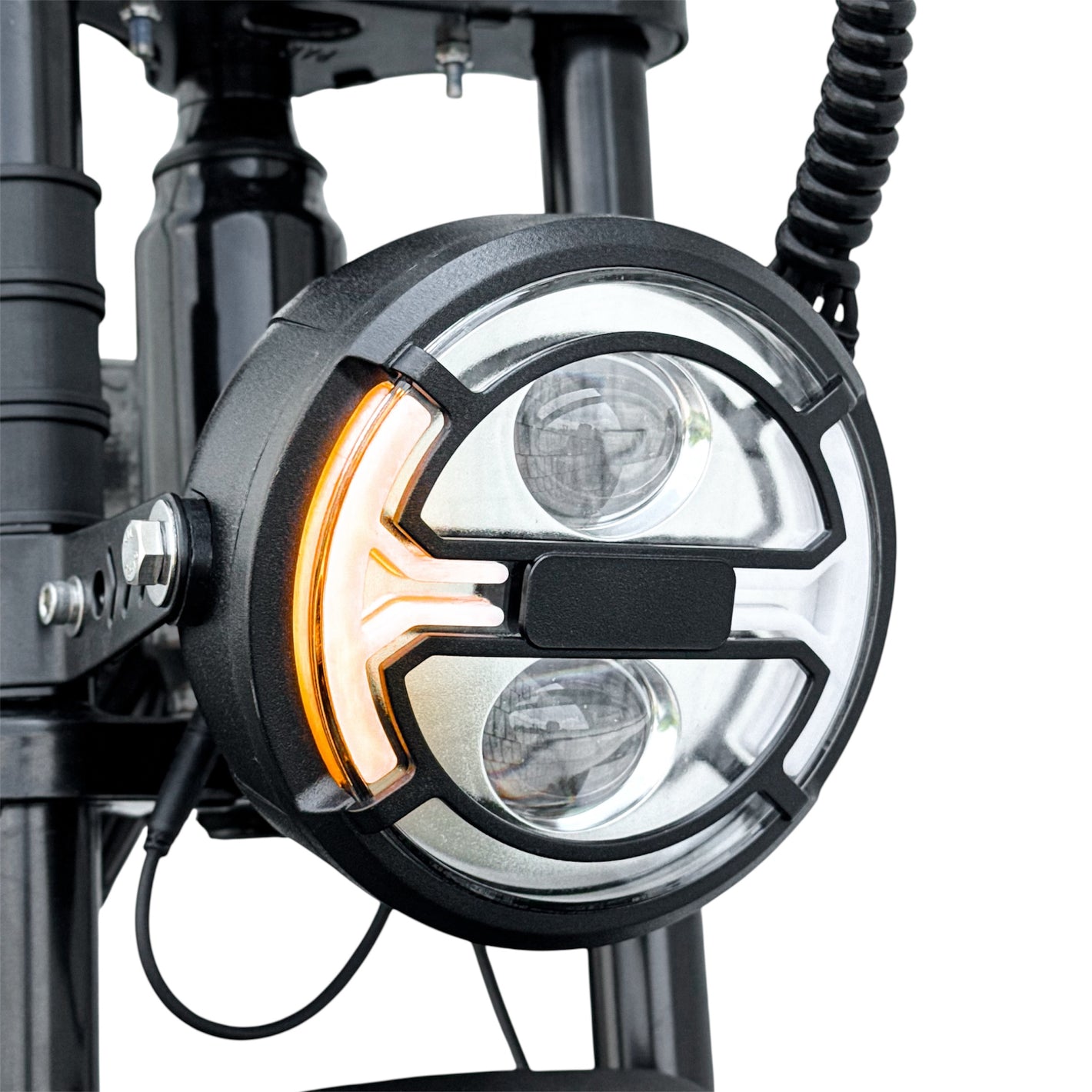 Close-up of a motorcycle headlight with visible signal indicator light on a white background