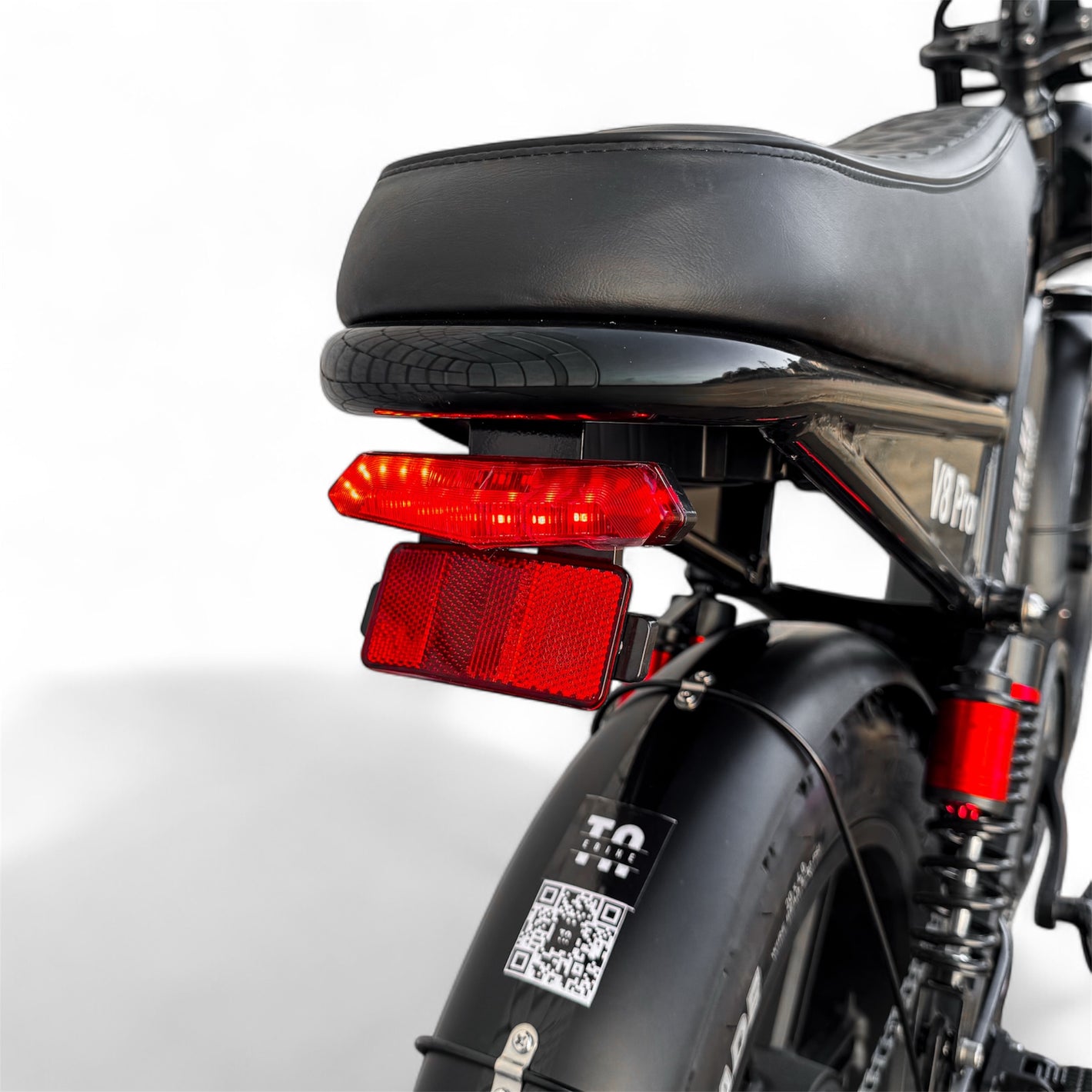 Close-up of a black electric bike's rear with red taillights on a white background