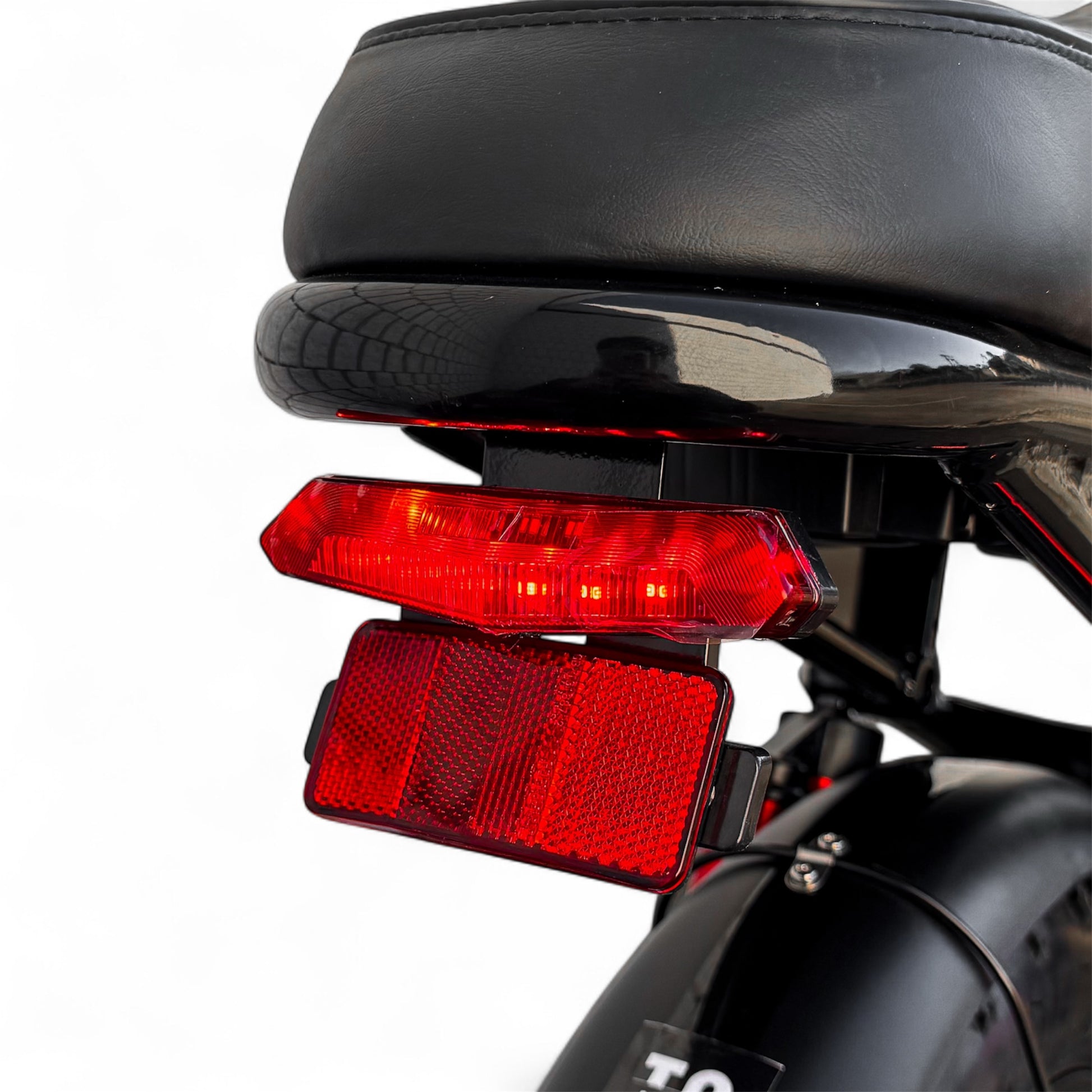 Red taillight on a black ebike seat with a white background